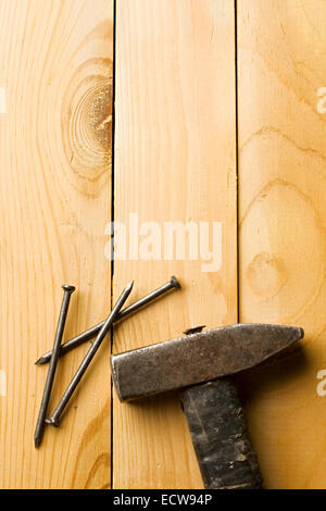 Hammer and nails isolated on wooden background Stock Photo