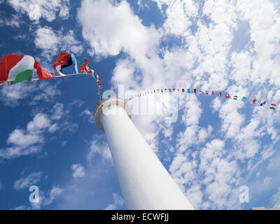 International flags fly from the Cape Zanpa Lighthouse, Yomitan, Okinawa, Japan Stock Photo