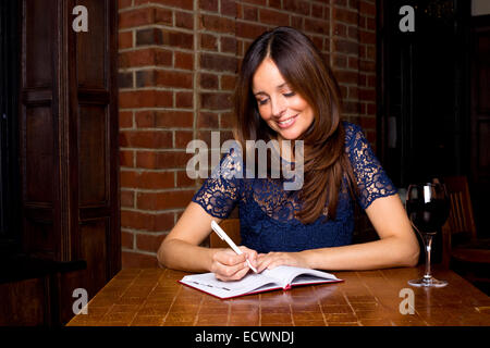 young woman writing in diary Stock Photo