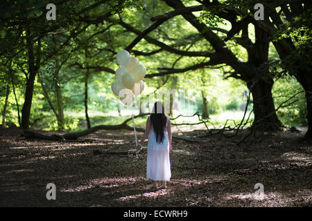Pregnant female in the woods holding balloons.  credit: LEE RAMSDEN / ALAMY Stock Photo