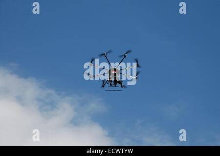 Aircraft type Dron photographed from the ground in flight and shooting events below it. Stock Photo