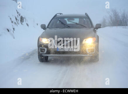 Car driving on snow and ice near the arctic circle in Sweden. Volvo XC70 using winter tyres Stock Photo
