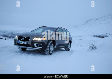 Car driving on snow and ice near the arctic circle in Sweden. Volvo XC70 using winter tyres Stock Photo