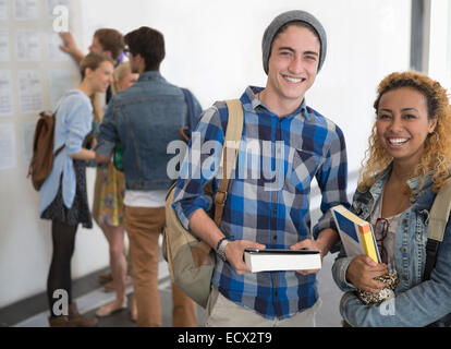 Portrait of two smiling university students standing in corridor Stock Photo