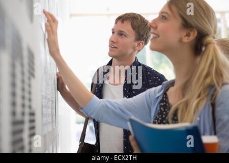 University students looking at test results in corridor Stock Photo