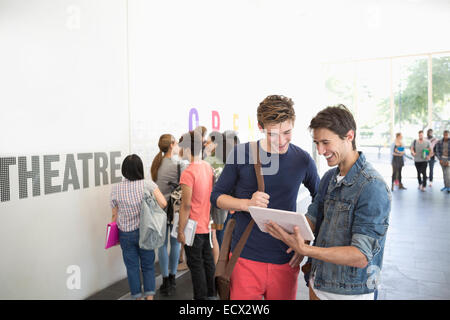 Two university friends looking at tablet in corridor Stock Photo