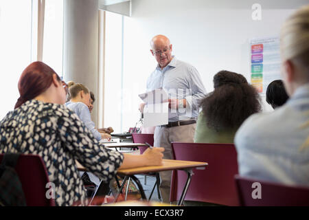 Professor giving exam results to university students Stock Photo