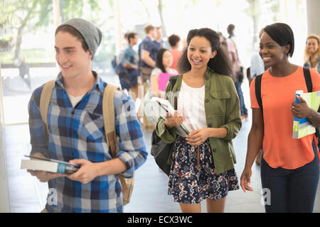 University students carrying books and walking to classroom Stock Photo