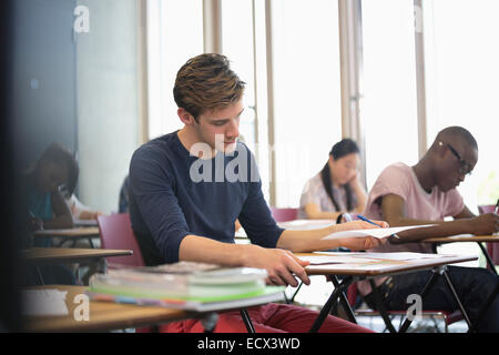 University student taking exam, students in background writing Stock Photo
