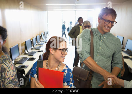 Professor greeting university students in classroom Stock Photo