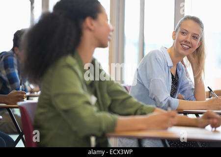 Smiling university students talking in classroom Stock Photo