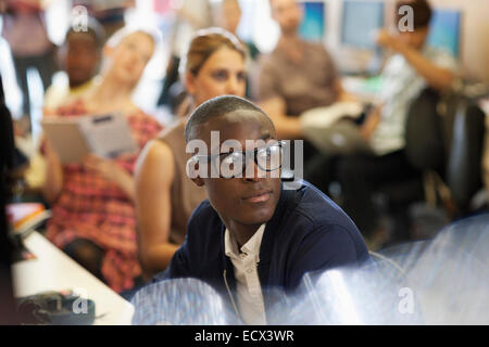 University student listening to IT seminar, students sitting in background Stock Photo