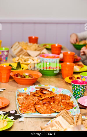 Colorful food and plastic crockery at a children's party Stock Photo