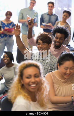 University students raising hands at IT seminar Stock Photo