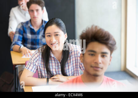 Portrait of smiling university students sitting in classroom Stock Photo