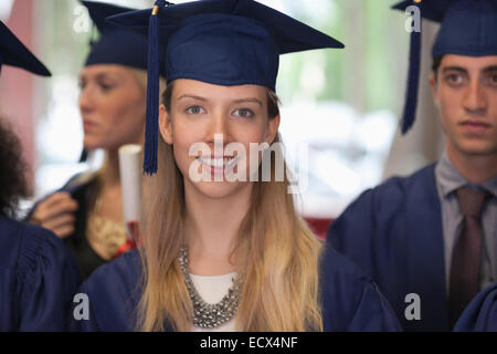 Female student in graduation clothes smiling at camera Stock Photo