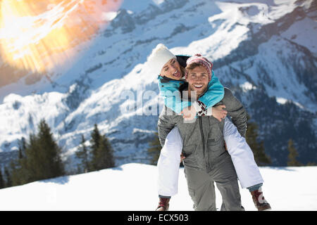 Couple piggybacking in snow Stock Photo