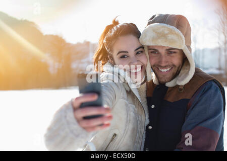 Couple taking selfie in snow Stock Photo