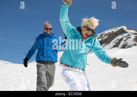 Exuberant couple playing in snow Stock Photo