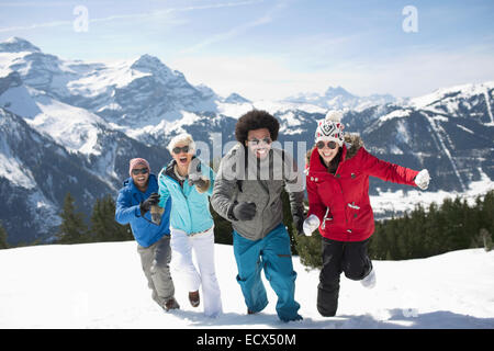 Friends running in snow Stock Photo