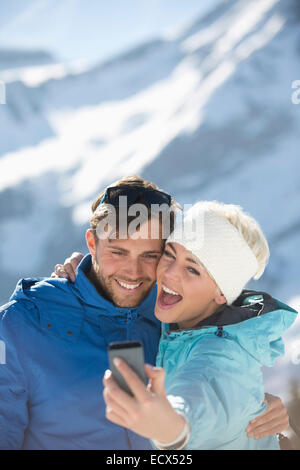 Couple taking selfie in snow Stock Photo