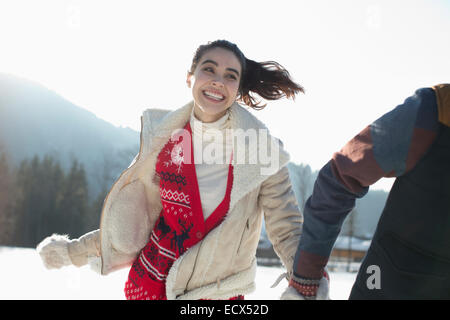 Couple running in snow Stock Photo