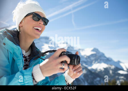 Smiling woman with camera at mountains Stock Photo