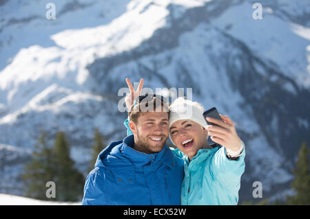 Couple taking selfie in snow Stock Photo