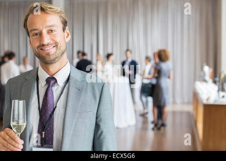 Portrait of smiling businessman holding champagne flute Stock Photo
