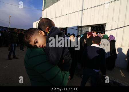 Gaza, Palestine. 21st Dec, 2014. A Palestinian man holds his boy, hoping to cross into Egypt, at the Rafah crossing between Egypt and the southern Gaza Strip, Dec. 21, 2014. Egypt temporarily reopened the Rafah border crossing on Sunday allowing Palestinians from Gaza Strip to travel in and out for the first time since it was closed on Oct. 25, officials in Gaza said. Egypt closed Rafah crossing following a series of deadly attacks carried out by radical Islamic militants in Sinai. After the attacks, the Egyptian army carried out the largest ever security campaign in Sinai. (Xinhua/K Stock Photo