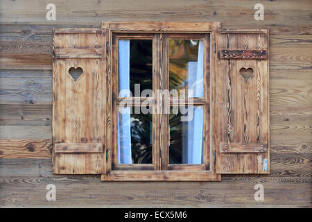 Open window of a wooden hut with hearts in the blinds Stock Photo