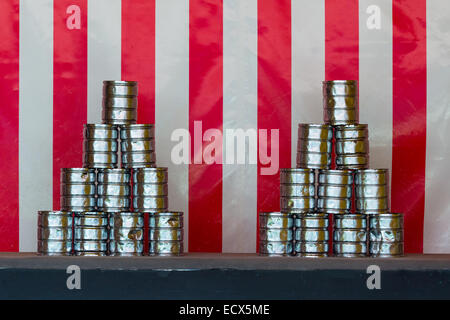 Two pyramids of tin cans for throwing balls at them on red white striped background Stock Photo