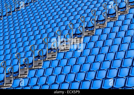 Stadium seating with blue folded up chairs Stock Photo
