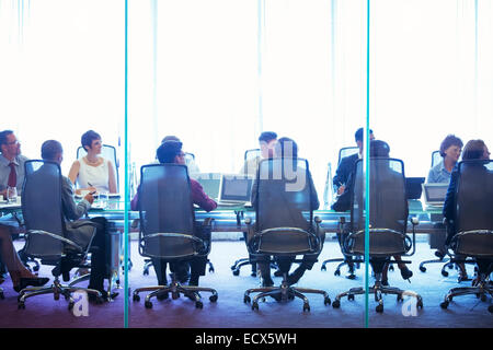 Business people having meeting in conference room, sitting with laptops and discussing Stock Photo