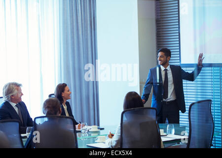 Businessman giving presentation to colleagues in conference room Stock Photo