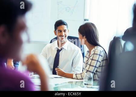 Businesswoman and businessman sitting and talking in conference room during business meeting Stock Photo