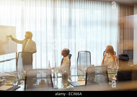 Mature businessman giving presentation to colleagues in conference room Stock Photo
