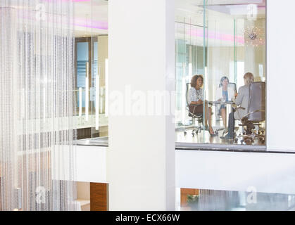Business people sitting in conference room, smiling and talking Stock Photo