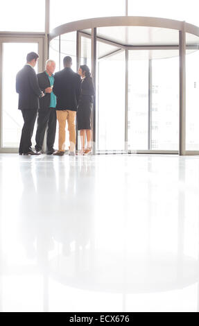 Business people standing and talking near front door of office Stock Photo