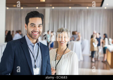 Portrait of man and woman standing in lobby of conference center smiling Stock Photo