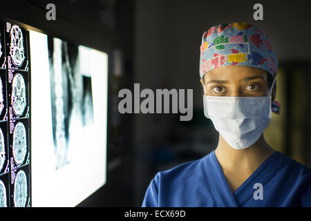Portrait of young female doctor standing near screen with MRI image Stock Photo