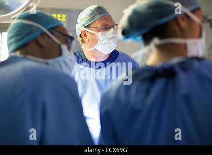 Doctors performing surgery in operating theater Stock Photo