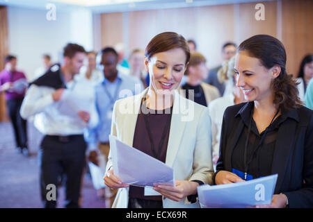 Two young businesswoman looking through files in conference room Stock Photo