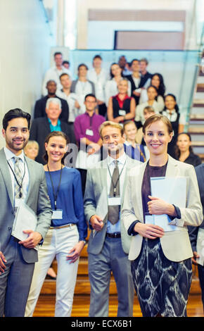 Portrait of men and women standing in lobby of conference center Stock Photo