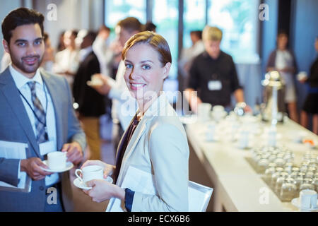 Portrait of man and woman standing in lobby of conference center during coffee break Stock Photo