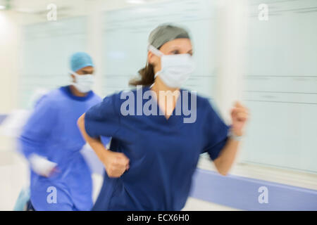 Doctors rushing through hospital corridor Stock Photo