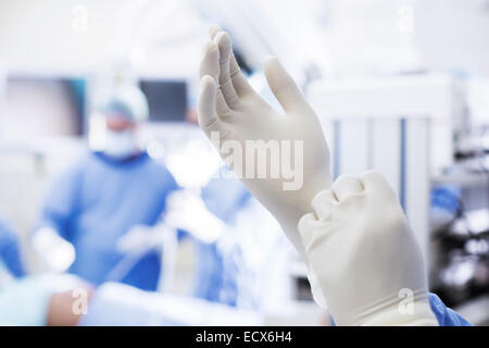 Close-up of surgeon putting on surgical gloves in operating theater Stock Photo
