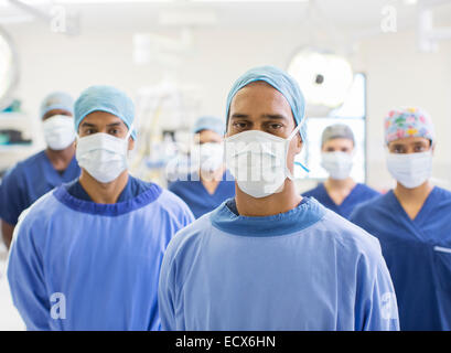 Group portrait of team of masked surgeons in hospital Stock Photo