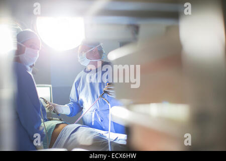 Doctors performing laparoscopic surgery in operating theater Stock Photo