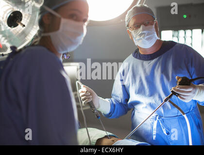 Male and female doctors performing laparoscopic surgery in operating theater Stock Photo